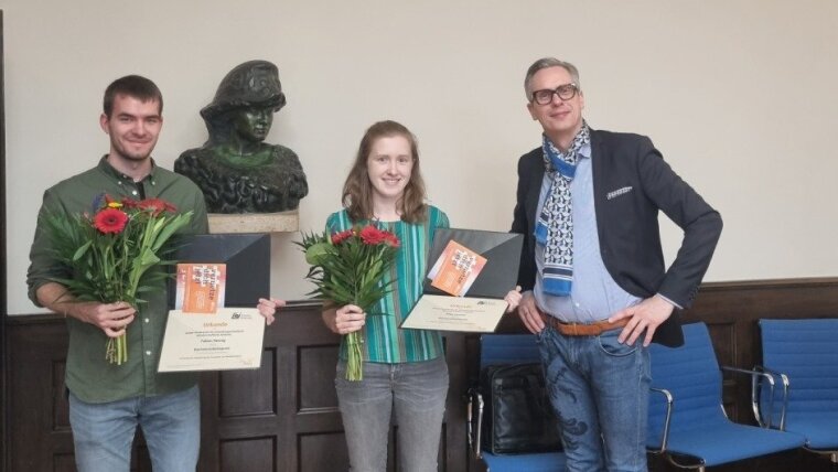 The chairman of Alumni Jenenses (on the right in the picture) hands over the 2022 thesis prizes to Fabian Hennig and Elisa Stumpf.